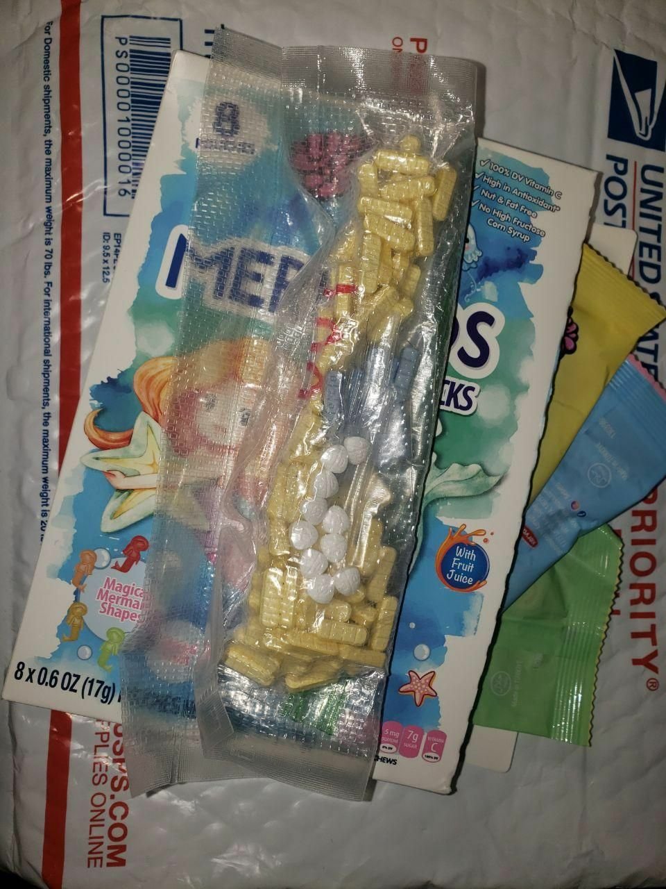 WWWWD – ZAZALAND COUNTER 🚬 Assorted yellow tablets and white pills in a plastic bag resting on packaging materials and a cereal box